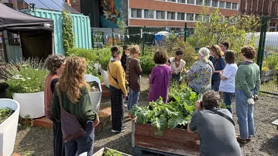 Projektteilnehmerinnen stehen draußen vor Pflanzenhochbeeten.