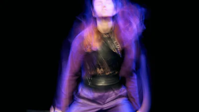 A young woman dances on a stage.