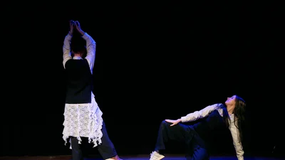 Zwei Tänzer auf einer Bühne während einer Performance.
