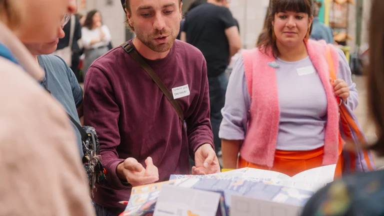 eine Person zeigt eine alternative Stadtkarte mit Kulturorten von Chemnitz