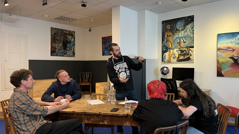 a group of young people is sitting around a table