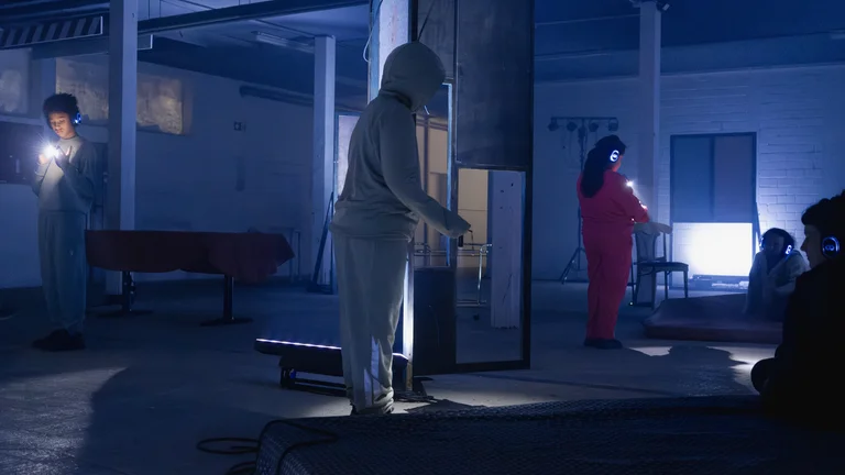Children with headphones and torches move around a room.